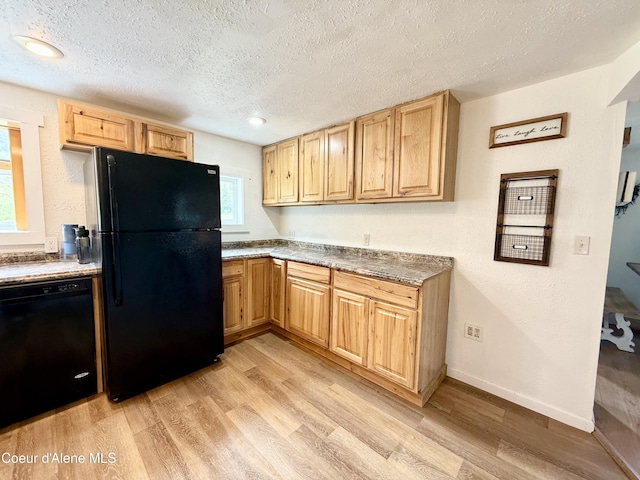 408 Quartz Crk Rd, Priest River, ID 83856 - kitchen featuring black appliances, light wood-style flooring, a textured ceiling, light brown cabinetry, and baseboards
