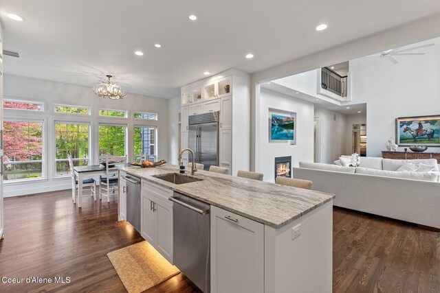 2946 E Point Hayden Dr, Hayden Lake, ID 83835 - kitchen featuring appliances with stainless steel finishes, a sink, recessed lighting, white cabinetry, and a glass covered fireplace