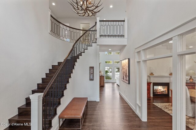 2946 E Point Hayden Dr, Hayden Lake, ID 83835 - entrance foyer with dark wood finished floors, stairway, a chandelier, a towering ceiling, and a glass covered fireplace