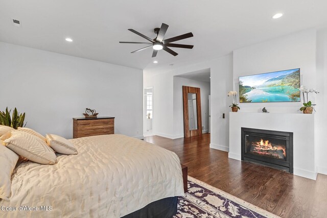 2946 E Point Hayden Dr, Hayden Lake, ID 83835 - bedroom featuring recessed lighting, a glass covered fireplace, dark wood-type flooring, a ceiling fan, and baseboards
