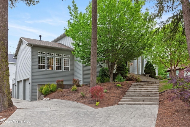 2946 E Point Hayden Dr, Hayden Lake, ID 83835 - view of property hidden behind natural elements featuring stairs, an attached garage, and concrete driveway