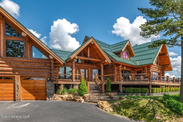 17442 S Painted Rose Rd, Worley, ID 83876 - log-style house featuring log siding, metal roof, a garage, asphalt driveway, and a deck