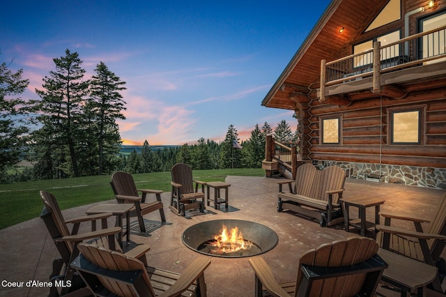 17442 S Painted Rose Rd, Worley, ID 83876 - patio terrace at dusk featuring a fire pit, a patio area, a balcony, and a yard