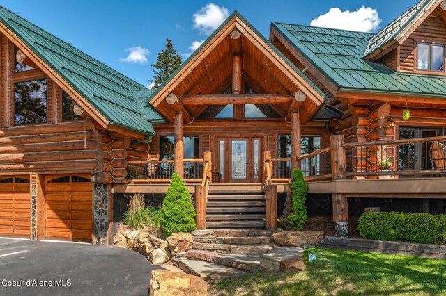 17442 S Painted Rose Rd, Worley, ID 83876 - view of front facade with a standing seam roof, log exterior, metal roof, stairs, and asphalt driveway