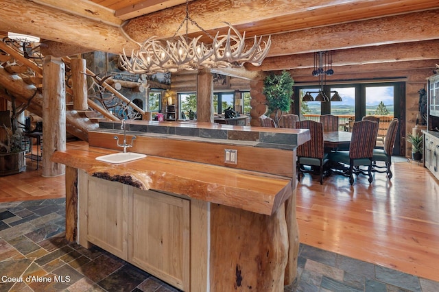17442 S Painted Rose Rd, Worley, ID 83876 - bar with a chandelier, a sink, log walls, beam ceiling, and stone tile floors