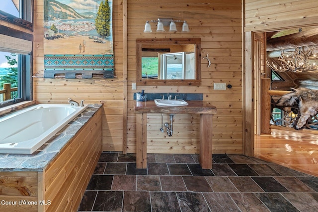 17442 S Painted Rose Rd, Worley, ID 83876 - bathroom featuring wooden walls, stone finish flooring, a bath, vanity, and a chandelier