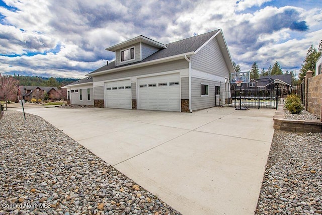 4732 W Mill River Ct, Coeur Dalene, ID 83814 - view of side of home with concrete driveway, stone siding, and a garage