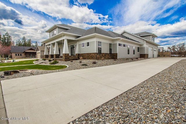 4732 W Mill River Ct, Coeur Dalene, ID 83814 - view of side of property with driveway, covered porch, stone siding, and a shingled roof