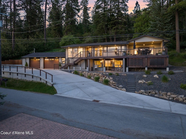 2406 S Silver Beach Rd, Coeur Dalene, ID 83814 - view of front of house featuring stairs, concrete driveway, an outbuilding, an attached garage, and a deck