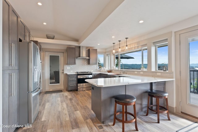 2406 S Silver Beach Rd, Coeur Dalene, ID 83814 - kitchen with stainless steel appliances, wall chimney exhaust hood, a peninsula, a sink, and recessed lighting