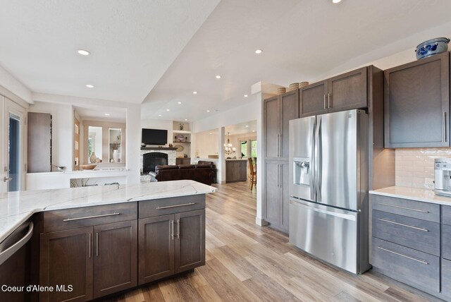2406 S Silver Beach Rd, Coeur Dalene, ID 83814 - kitchen featuring stainless steel appliances, dark brown cabinets, recessed lighting, light wood-style floors, and backsplash