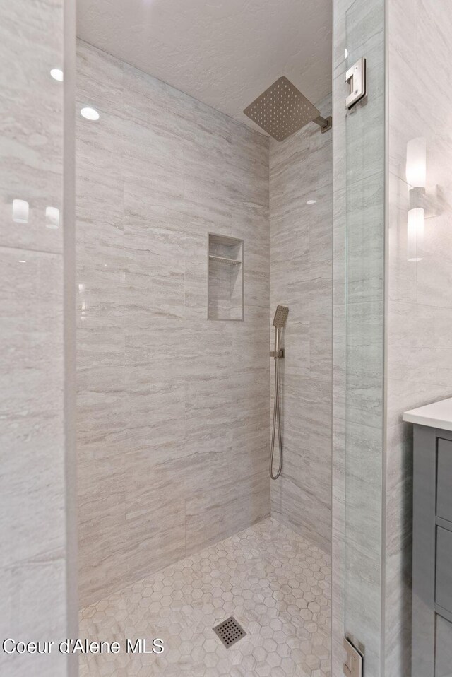 2406 S Silver Beach Rd, Coeur Dalene, ID 83814 - bathroom featuring a tile shower and vanity