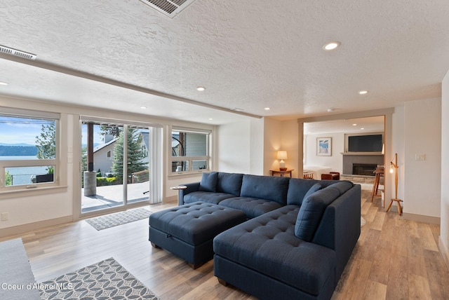 2406 S Silver Beach Rd, Coeur Dalene, ID 83814 - living area with light wood-type flooring, recessed lighting, a fireplace, baseboards, and a textured ceiling