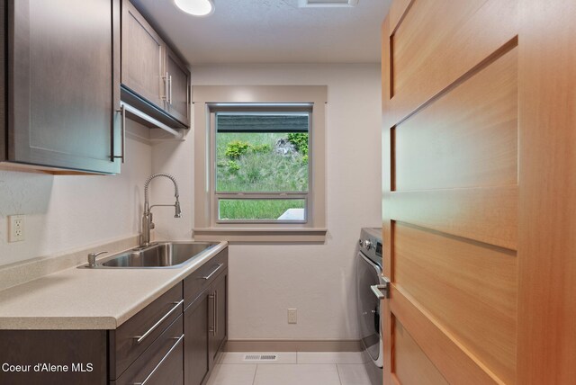 2406 S Silver Beach Rd, Coeur Dalene, ID 83814 - kitchen featuring a sink, baseboards, light countertops, light tile patterned flooring, and dark brown cabinetry