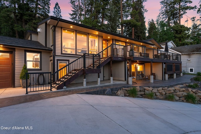 2406 S Silver Beach Rd, Coeur Dalene, ID 83814 - back of property at dusk featuring stairway, a patio area, and a deck