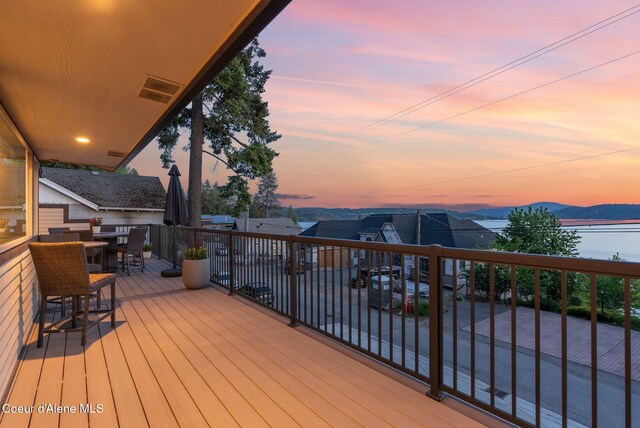 2406 S Silver Beach Rd, Coeur Dalene, ID 83814 - deck at dusk featuring a mountain view and outdoor dining space
