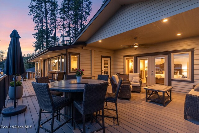 2406 S Silver Beach Rd, Coeur Dalene, ID 83814 - deck at dusk with outdoor dining space and ceiling fan