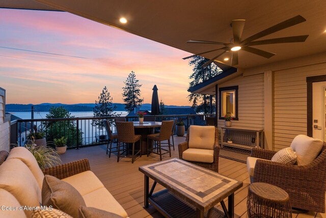 2406 S Silver Beach Rd, Coeur Dalene, ID 83814 - wooden deck featuring outdoor dining space, a water view, and a ceiling fan