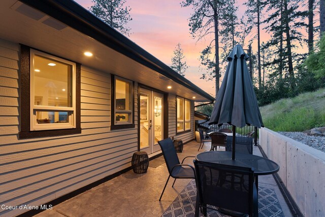 2406 S Silver Beach Rd, Coeur Dalene, ID 83814 - patio terrace at dusk featuring outdoor dining space and a patio area
