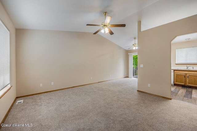 11221 N Crusader St, Hayden, ID 83835 - unfurnished living room featuring light colored carpet, ceiling fan, baseboards, a sink, and lofted ceiling