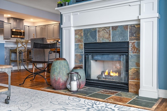 4797 S Arrow Point Dr Unit 104, Harrison, ID 83833 - detailed view of a tile fireplace, stainless steel microwave, wood finished floors, recessed lighting, and baseboards