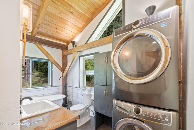 99 Broten Way, Sagle, ID 83860 - laundry area featuring stacked washer / dryer, wood ceiling, tile walls, and tile patterned floors