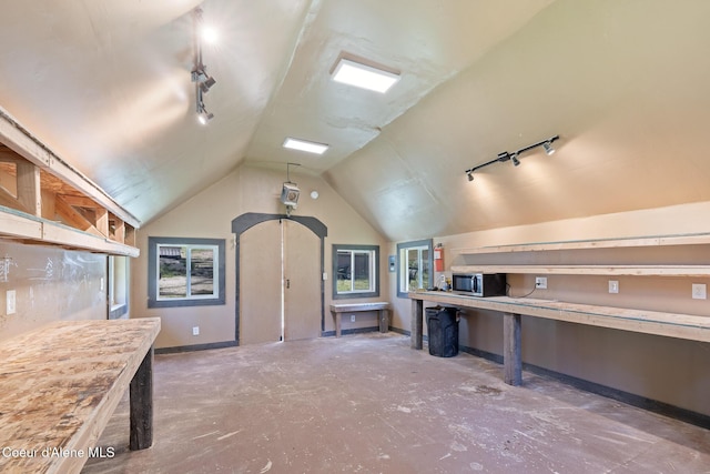 99 Broten Way, Sagle, ID 83860 - kitchen with rail lighting, stainless steel microwave, unfinished concrete flooring, lofted ceiling, and baseboards