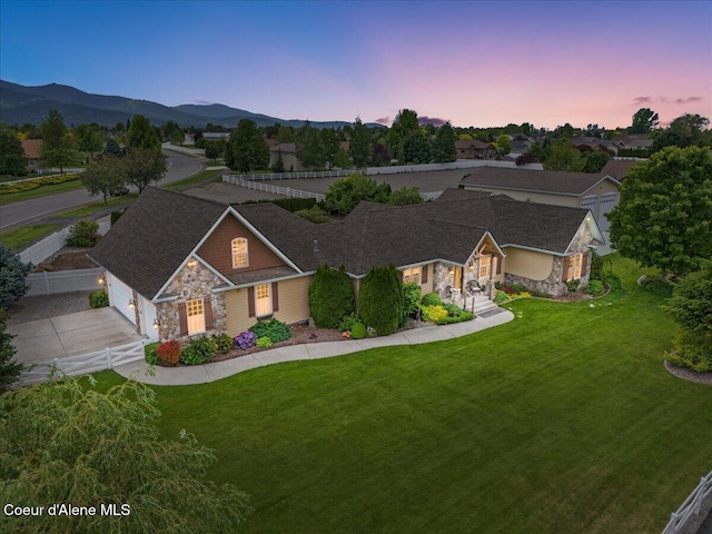 1874 W Polo Green Ave, Post Falls, ID 83854 - view of front of property with stone siding, a garage, a mountain view, and concrete driveway