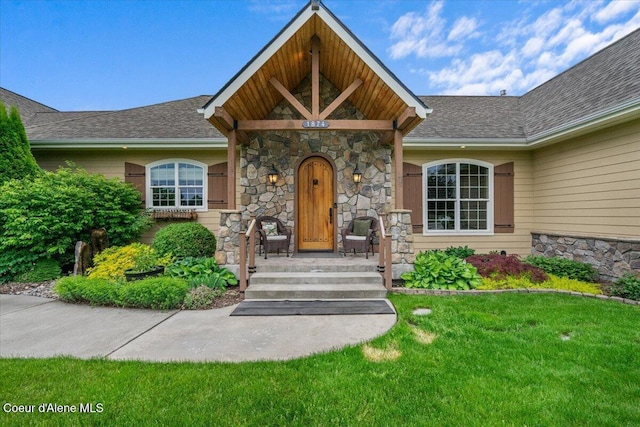 1874 W Polo Green Ave, Post Falls, ID 83854 - entrance to property featuring stone siding, covered porch, a lawn, and roof with shingles
