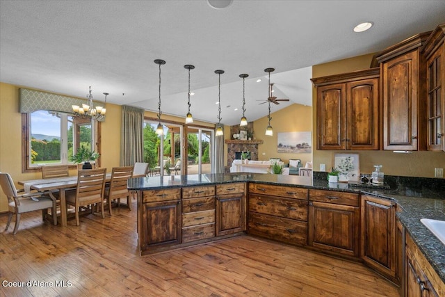 1874 W Polo Green Ave, Post Falls, ID 83854 - kitchen featuring a peninsula, decorative light fixtures, a chandelier, light wood-style floors, and lofted ceiling