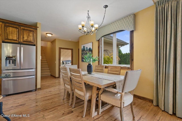 1874 W Polo Green Ave, Post Falls, ID 83854 - dining area with a chandelier, light wood-style floors, baseboards, and stairs