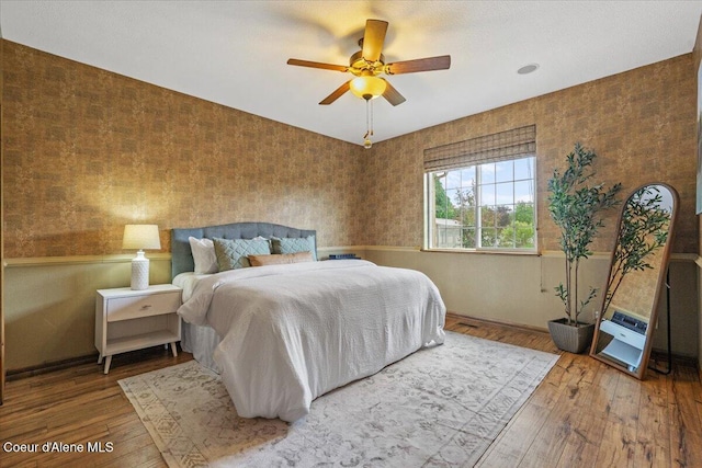 1874 W Polo Green Ave, Post Falls, ID 83854 - bedroom featuring hardwood / wood-style floors, wallpapered walls, baseboards, and a ceiling fan