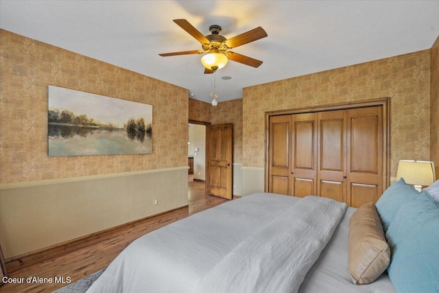 1874 W Polo Green Ave, Post Falls, ID 83854 - bedroom featuring wood finished floors, a closet, wallpapered walls, wainscoting, and baseboards