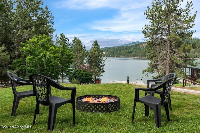 176 Swan Shores Dr, Sagle, ID 83860 - view of green lawn with an outdoor fire pit, a water view, and a view of trees