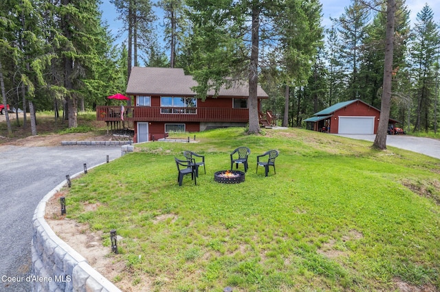 176 Swan Shores Dr, Sagle, ID 83860 - chalet / cabin with a fire pit, a deck, an outbuilding, a front yard, and a detached garage