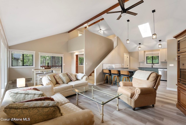 176 Swan Shores Dr, Sagle, ID 83860 - living room with a ceiling fan, light wood-type flooring, a skylight, stairs, and high vaulted ceiling