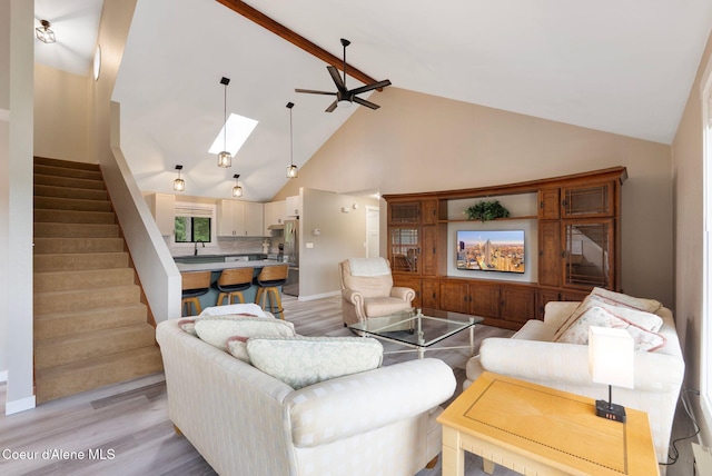176 Swan Shores Dr, Sagle, ID 83860 - living room featuring high vaulted ceiling, stairs, light wood finished floors, beamed ceiling, and a skylight