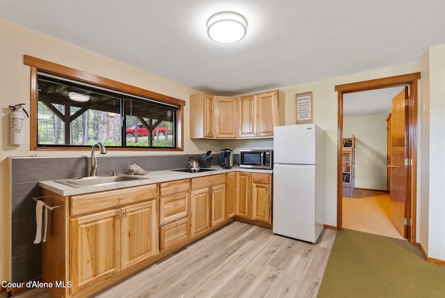 176 Swan Shores Dr, Sagle, ID 83860 - kitchen featuring freestanding refrigerator, stainless steel microwave, a sink, light brown cabinets, and light countertops