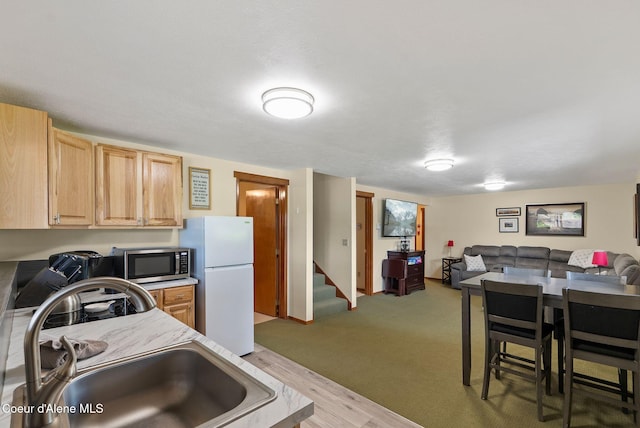 176 Swan Shores Dr, Sagle, ID 83860 - kitchen with freestanding refrigerator, stainless steel microwave, open floor plan, a sink, and light countertops