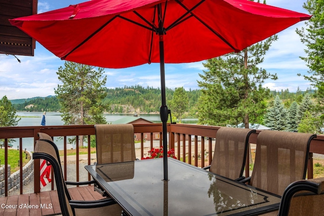 176 Swan Shores Dr, Sagle, ID 83860 - deck featuring outdoor dining space, a view of trees, and a water view