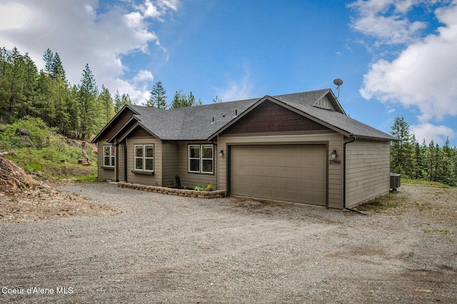 27968 N Timber Ridge Rd, Rathdrum, ID 83858 - view of front facade featuring central air condition unit, a garage, driveway, and roof with shingles