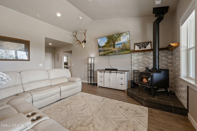 27968 N Timber Ridge Rd, Rathdrum, ID 83858 - living room with a wood stove, lofted ceiling, wood finished floors, baseboards, and recessed lighting
