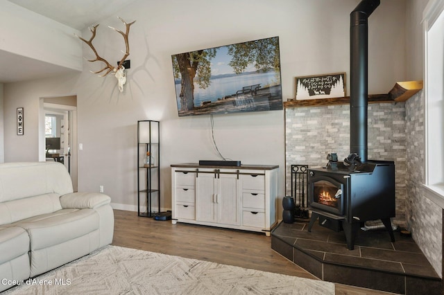 27968 N Timber Ridge Rd, Rathdrum, ID 83858 - living room featuring a wood stove, wood finished floors, and baseboards