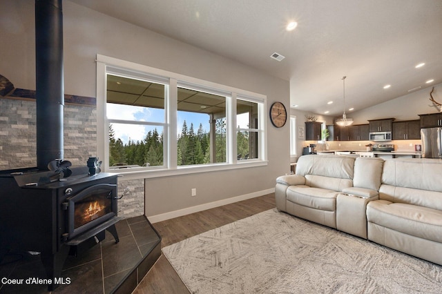 27968 N Timber Ridge Rd, Rathdrum, ID 83858 - living area with a wood stove, wood finished floors, recessed lighting, lofted ceiling, and baseboards