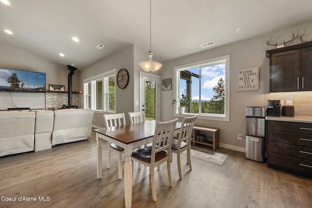 27968 N Timber Ridge Rd, Rathdrum, ID 83858 - dining room featuring a wood stove, light wood-type flooring, recessed lighting, plenty of natural light, and baseboards