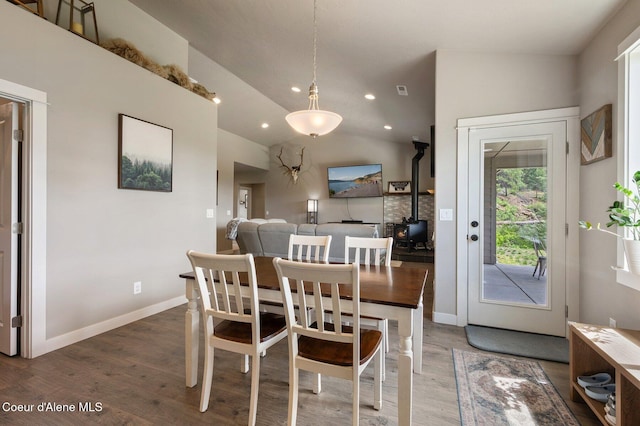27968 N Timber Ridge Rd, Rathdrum, ID 83858 - dining room with wood finished floors, recessed lighting, vaulted ceiling, a wood stove, and baseboards