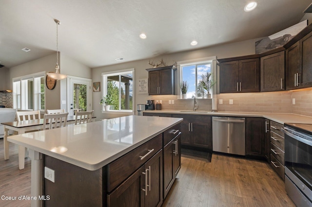 27968 N Timber Ridge Rd, Rathdrum, ID 83858 - kitchen featuring appliances with stainless steel finishes, a sink, decorative backsplash, wood finished floors, and dark brown cabinets