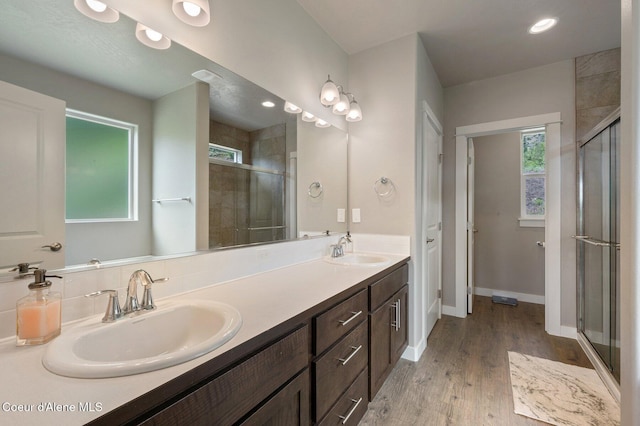 27968 N Timber Ridge Rd, Rathdrum, ID 83858 - bathroom featuring a shower stall, wood finished floors, double vanity, baseboards, and recessed lighting