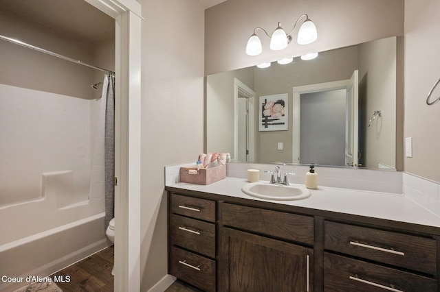 27968 N Timber Ridge Rd, Rathdrum, ID 83858 - bathroom featuring toilet, vanity, wood finished floors, and shower / bathtub combination with curtain