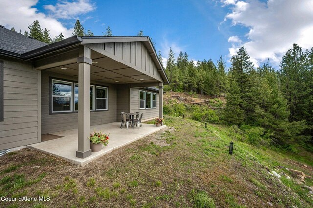 27968 N Timber Ridge Rd, Rathdrum, ID 83858 - rear view of property with a patio area and board and batten siding
